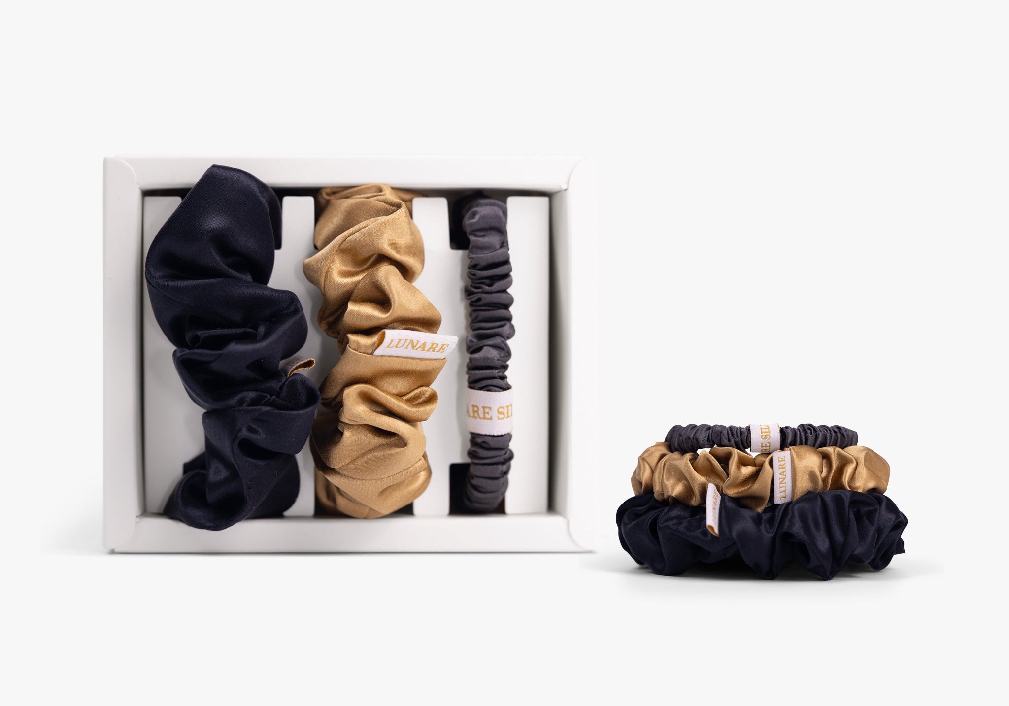 Classic neutral silk scrunchies in open gift box on white background