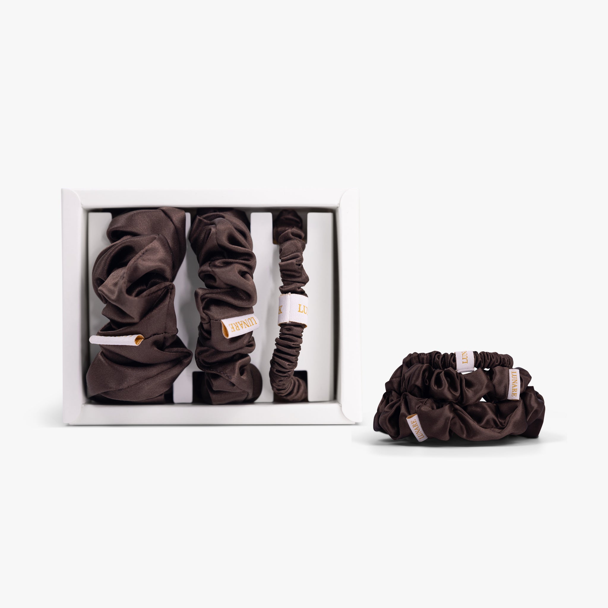 Coffee silk scrunchies in open box with stacked set on white background
