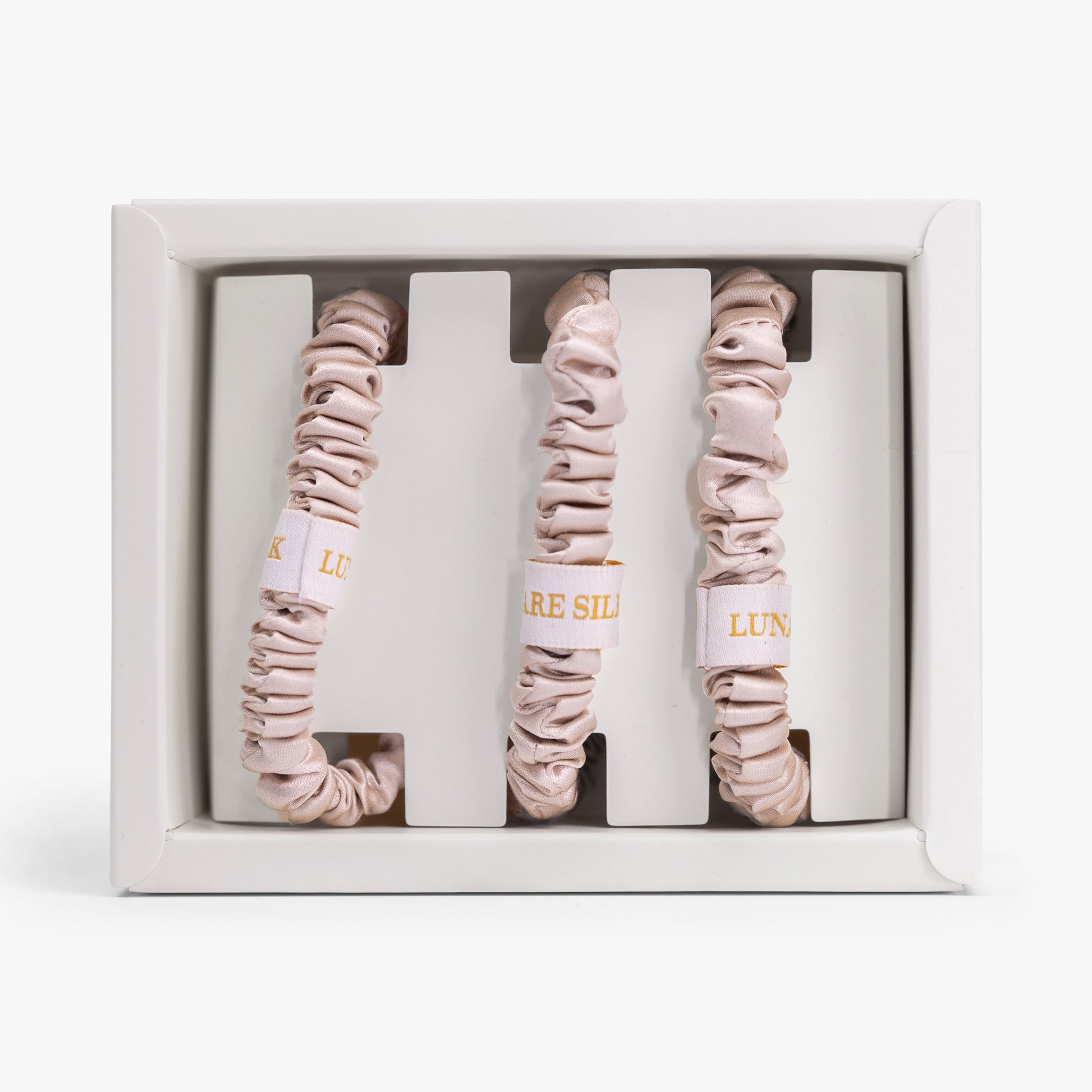 Three champagne scrunchies in a white box with 'Luna' branding