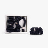 Black silk scrunchies in open box with stacked set on white background
