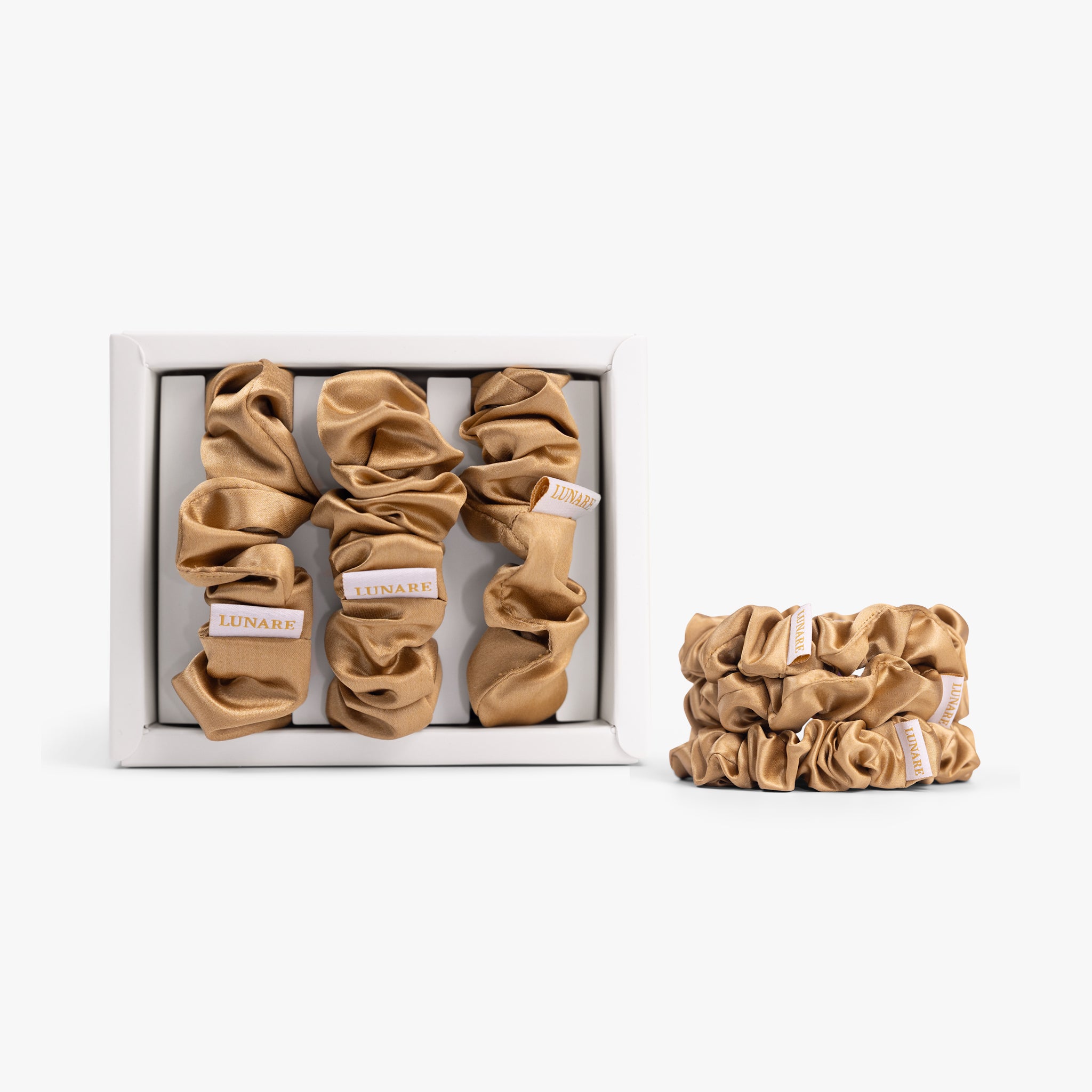 Amber gold large silk scrunchie in open box on white background
