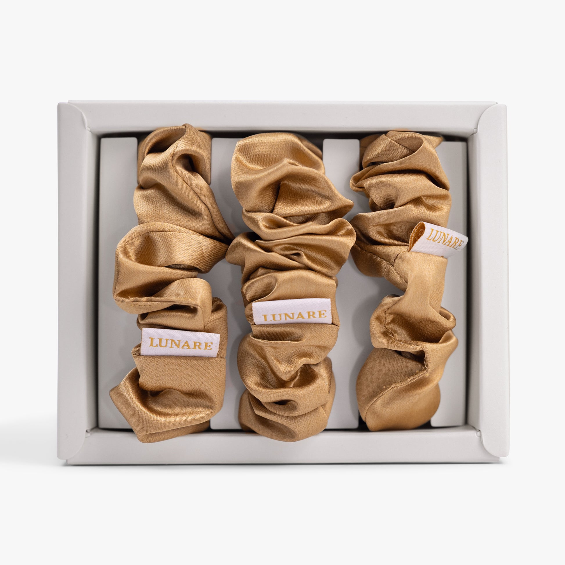 Amber gold large silk scrunchie in open box top view
