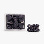 Dark grey large silk scrunchie in open box on white background
