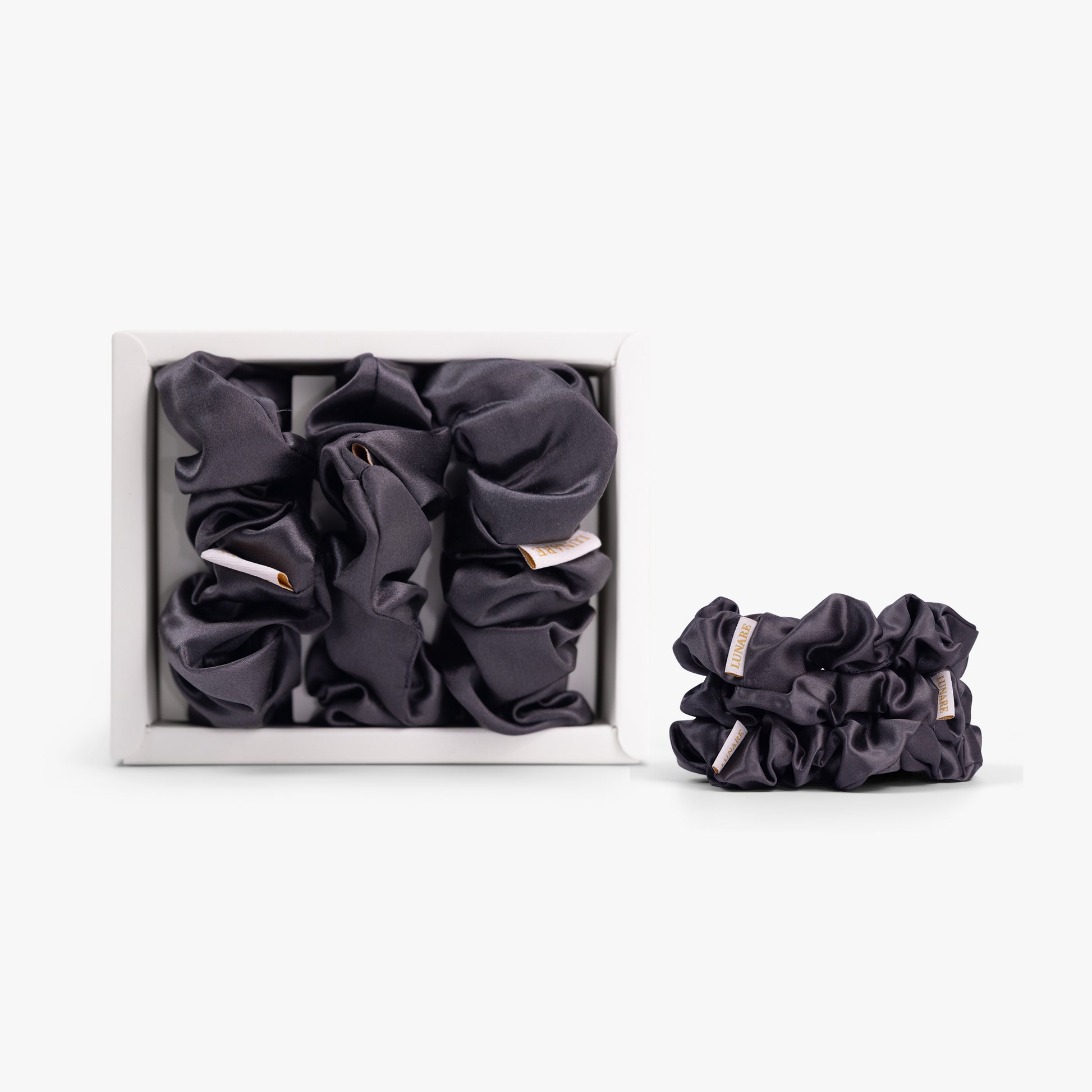 Dark grey large silk scrunchie in open box on white background
