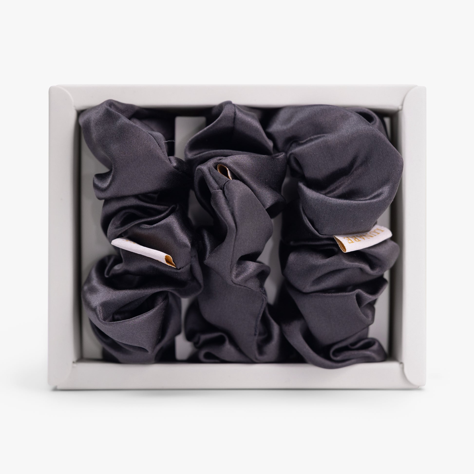 Dark grey large silk scrunchie in open box top view
