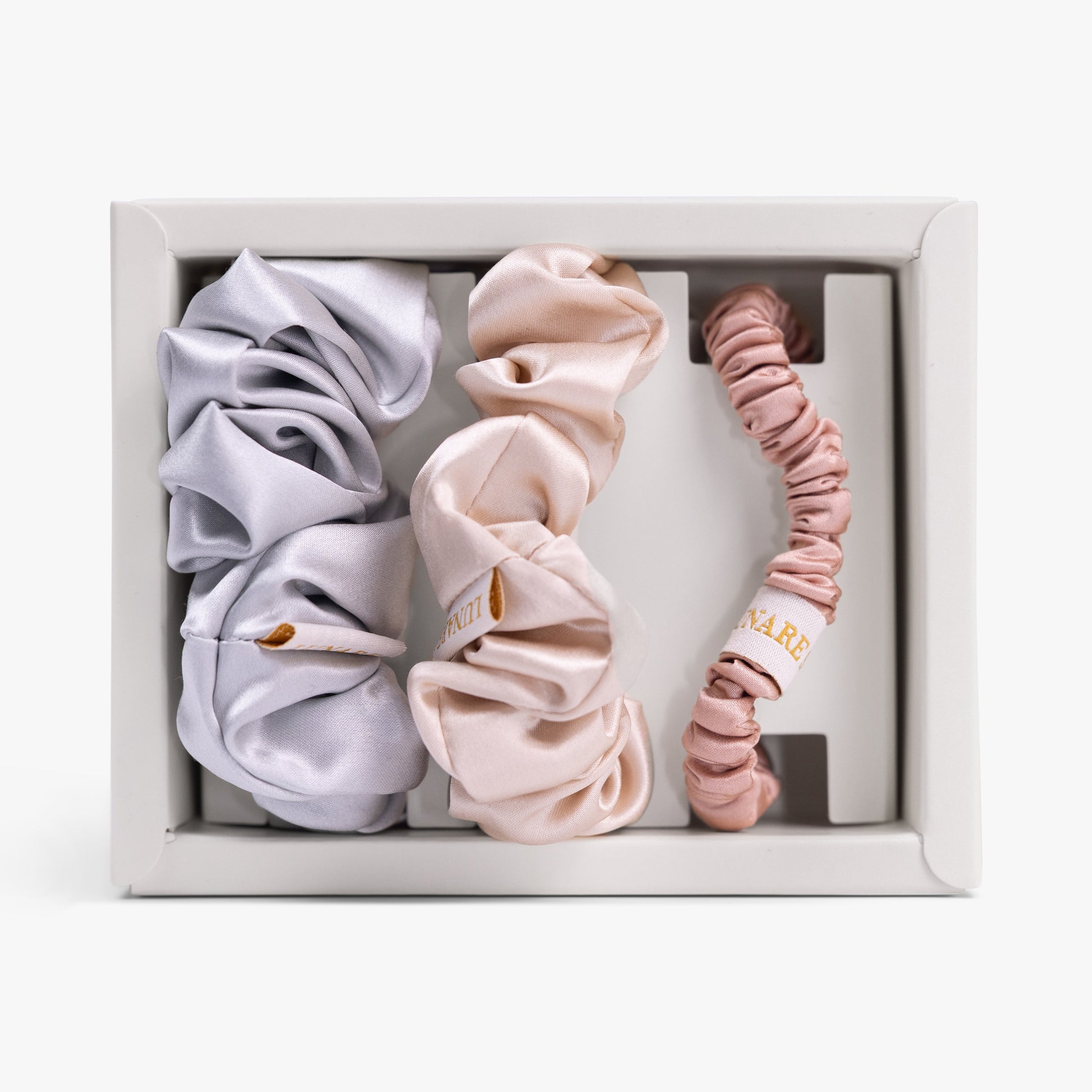 Soft neutral silk scrunchies set in open box top view
