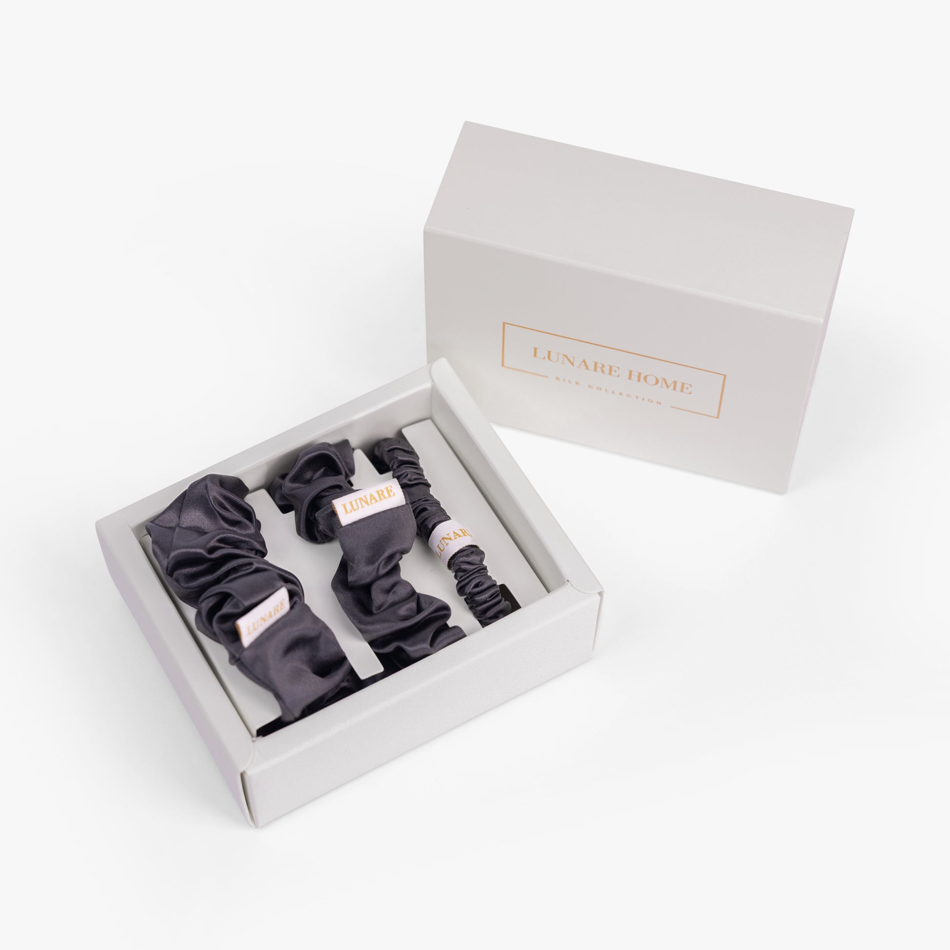 Dark grey silk scrunchies in open gift box with Lunare Home lid
