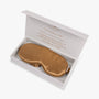 Amber gold silk eye mask in open gift box

