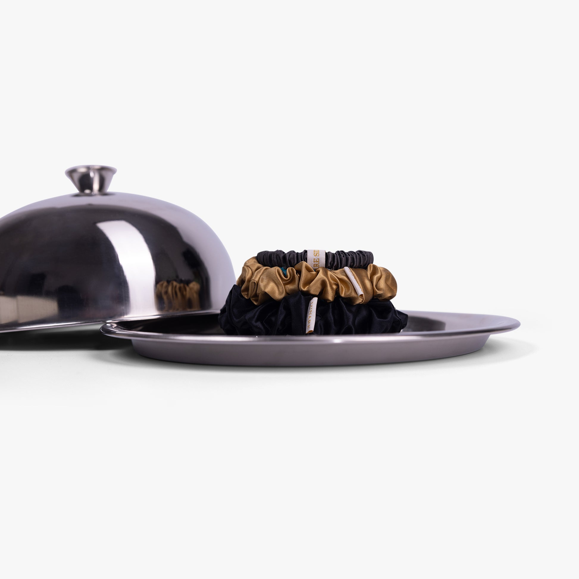 Classic neutral silk scrunchies on silver tray with lid
