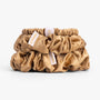 Amber gold silk scrunchies stacked from large to small on white background
