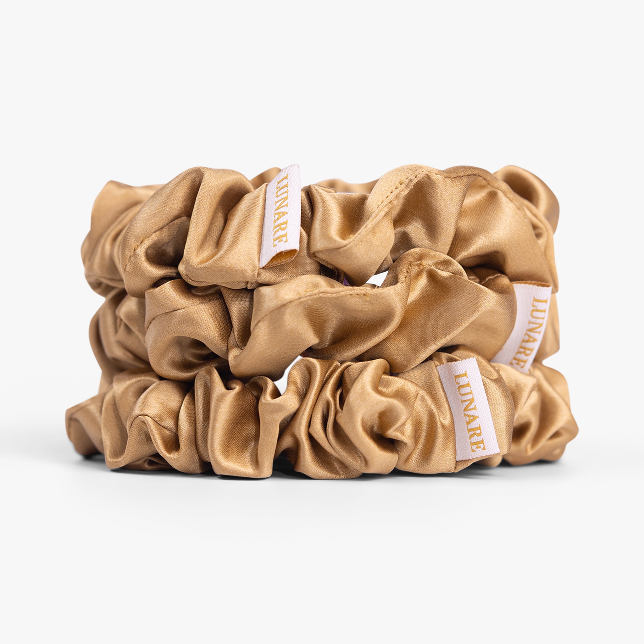 Amber gold large silk scrunchie on white background
