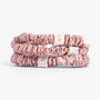 Rose gold silk scrunchies stacked on white background
