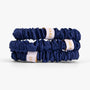 Two navy blue hair scrunchies with white labels on a white background