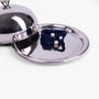 Navy blue hair ties with gold accents on a silver tray