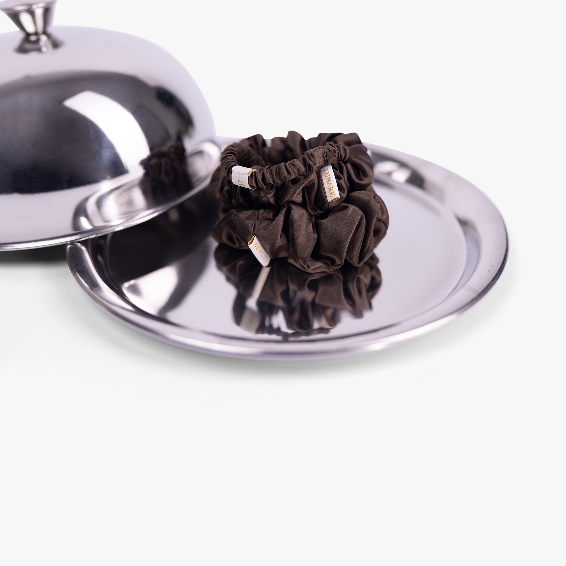 Coffee silk scrunchies on silver tray with lid
