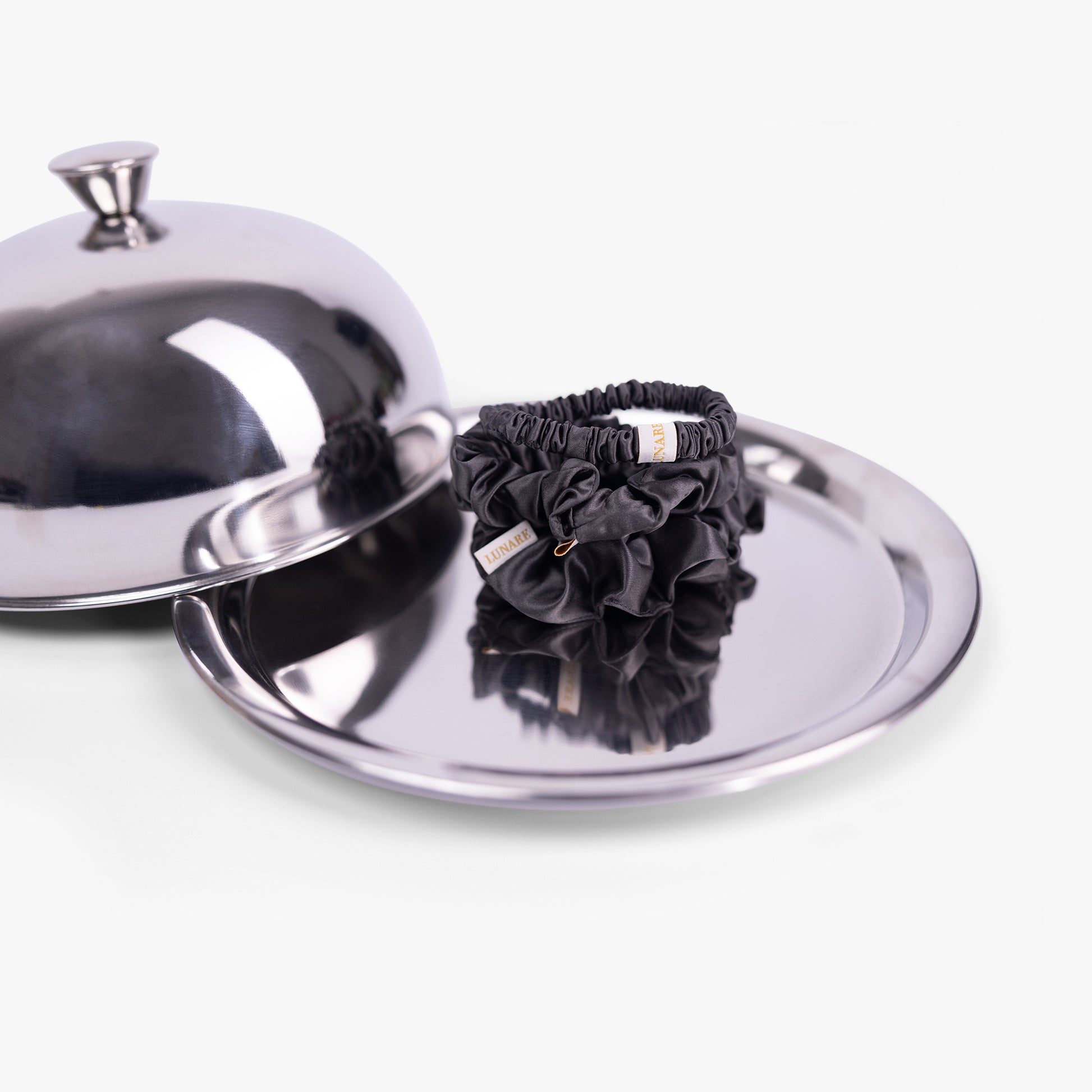 Dark grey silk scrunchies on silver tray with lid
