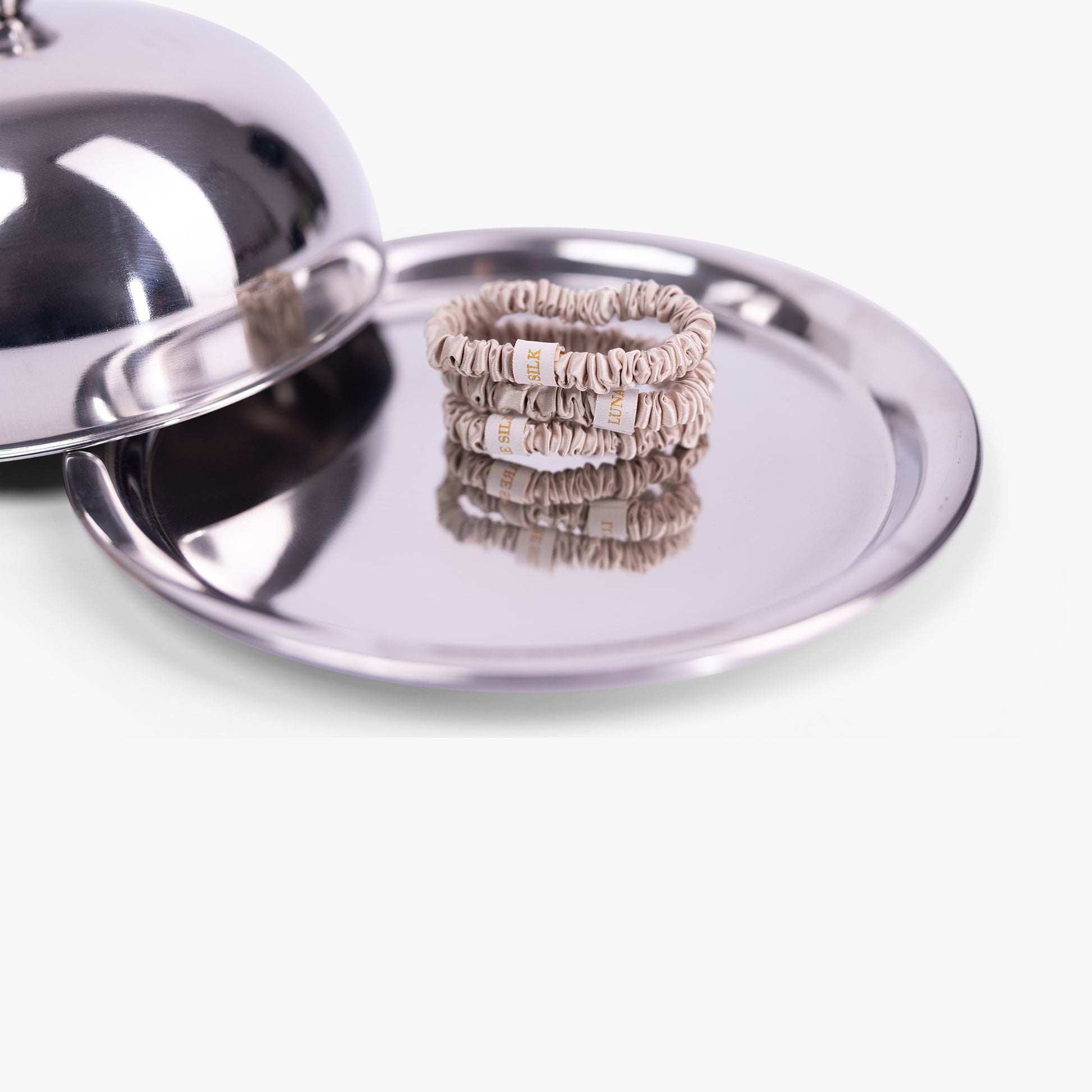 Stack of rings on a silver tray with a silver lid