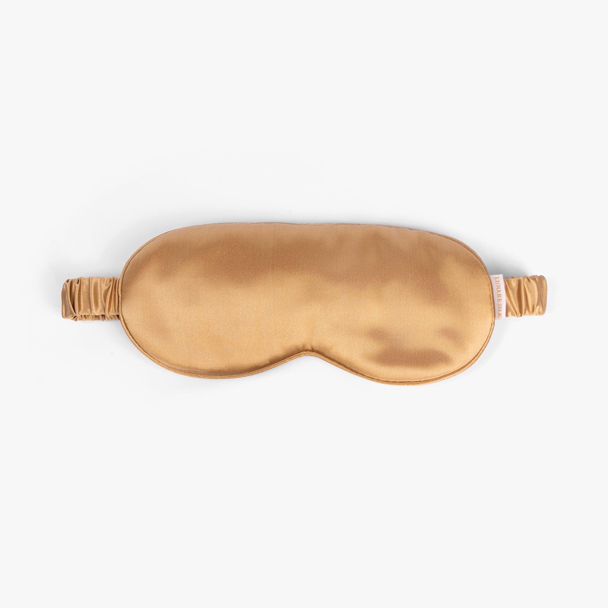 Amber gold silk eye mask on white background
