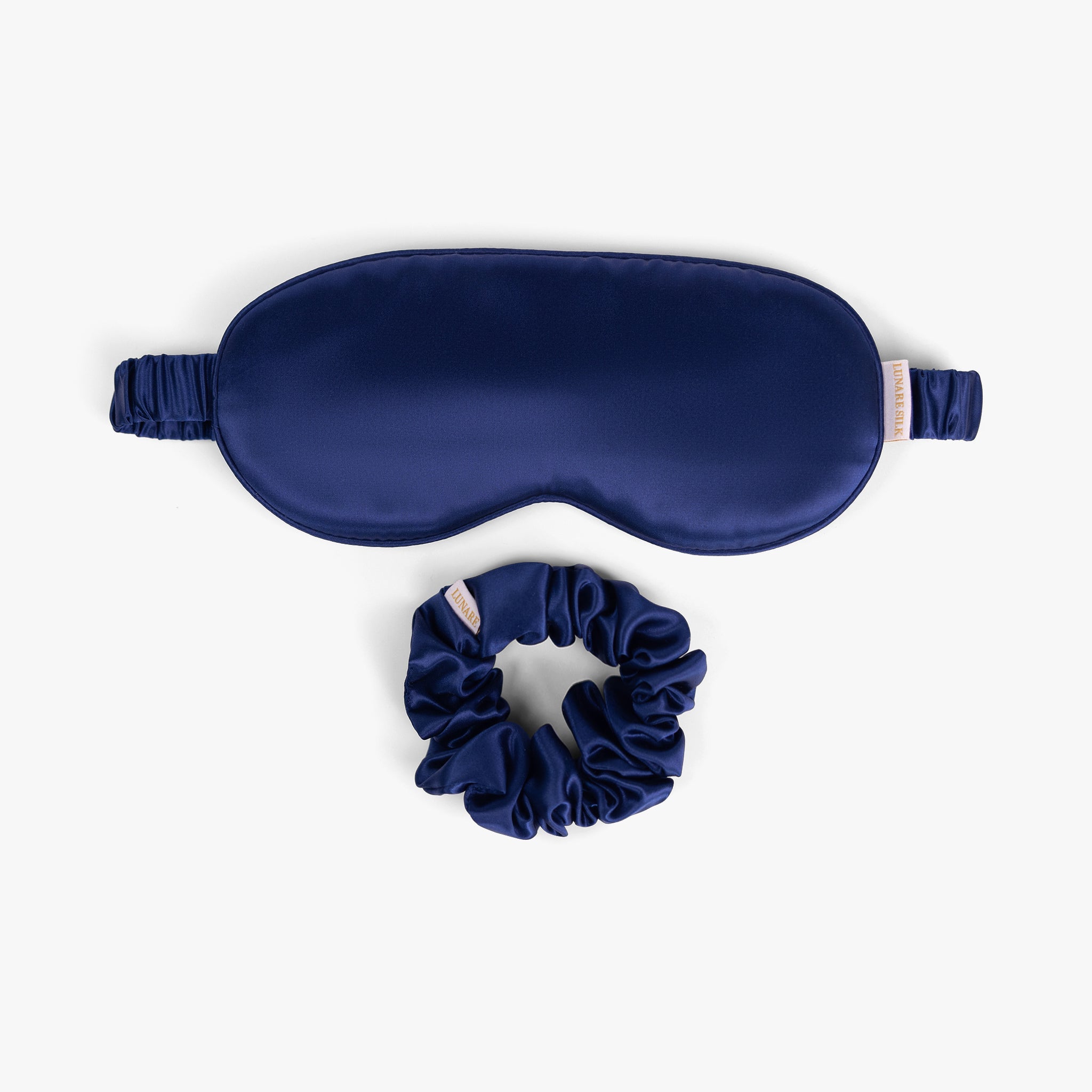 Navy blue care silk bundle with eye mask and scrunchie on white background
