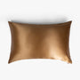 Amber gold silk pillowcase on white background
