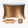 Amber gold ritual silk bundle with pillowcase, eye mask and scrunchie on white background
