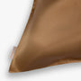 Amber gold silk pillowcase logo close-up

