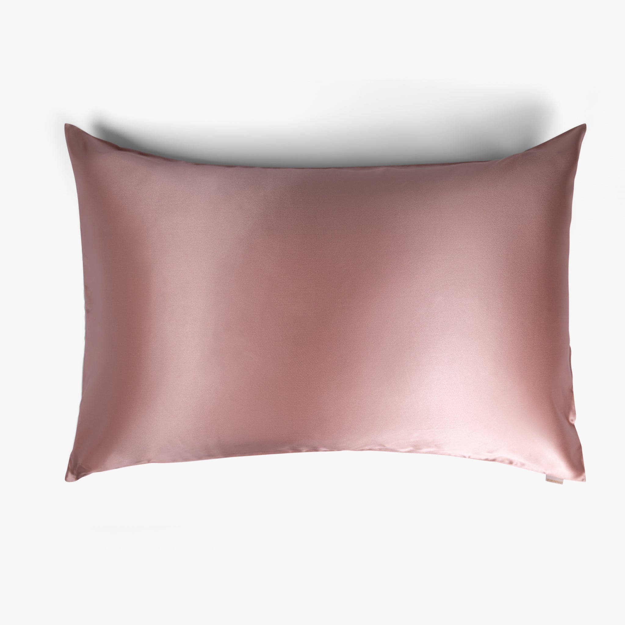 Rose gold silk pillowcase on white background
