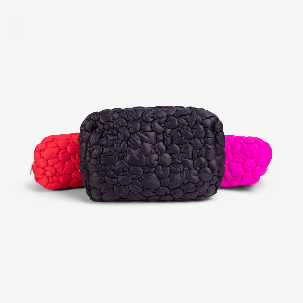 Black quilted floral cosmetic bag with gold hardware
